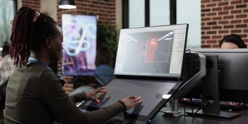 creative-agency-production-department-team-leader-developing-professional-game-technology-3d-digital-artist-sitting-at-computer-desk-while-working-on-environmental-design